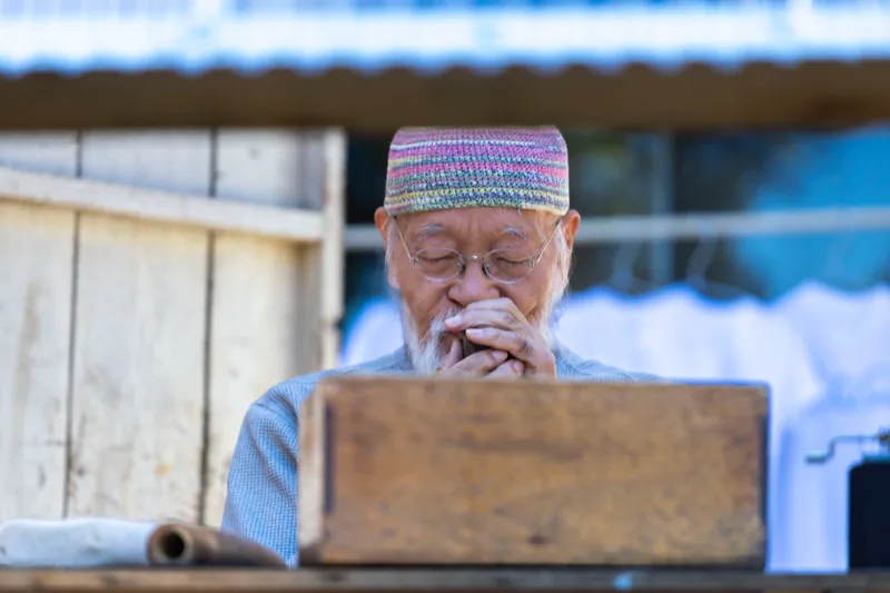 Akio Suzuki performing in front of the hut