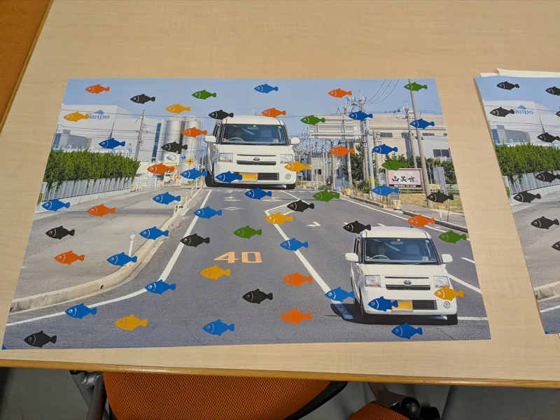 A test print with fish scattered over a photograph of cars