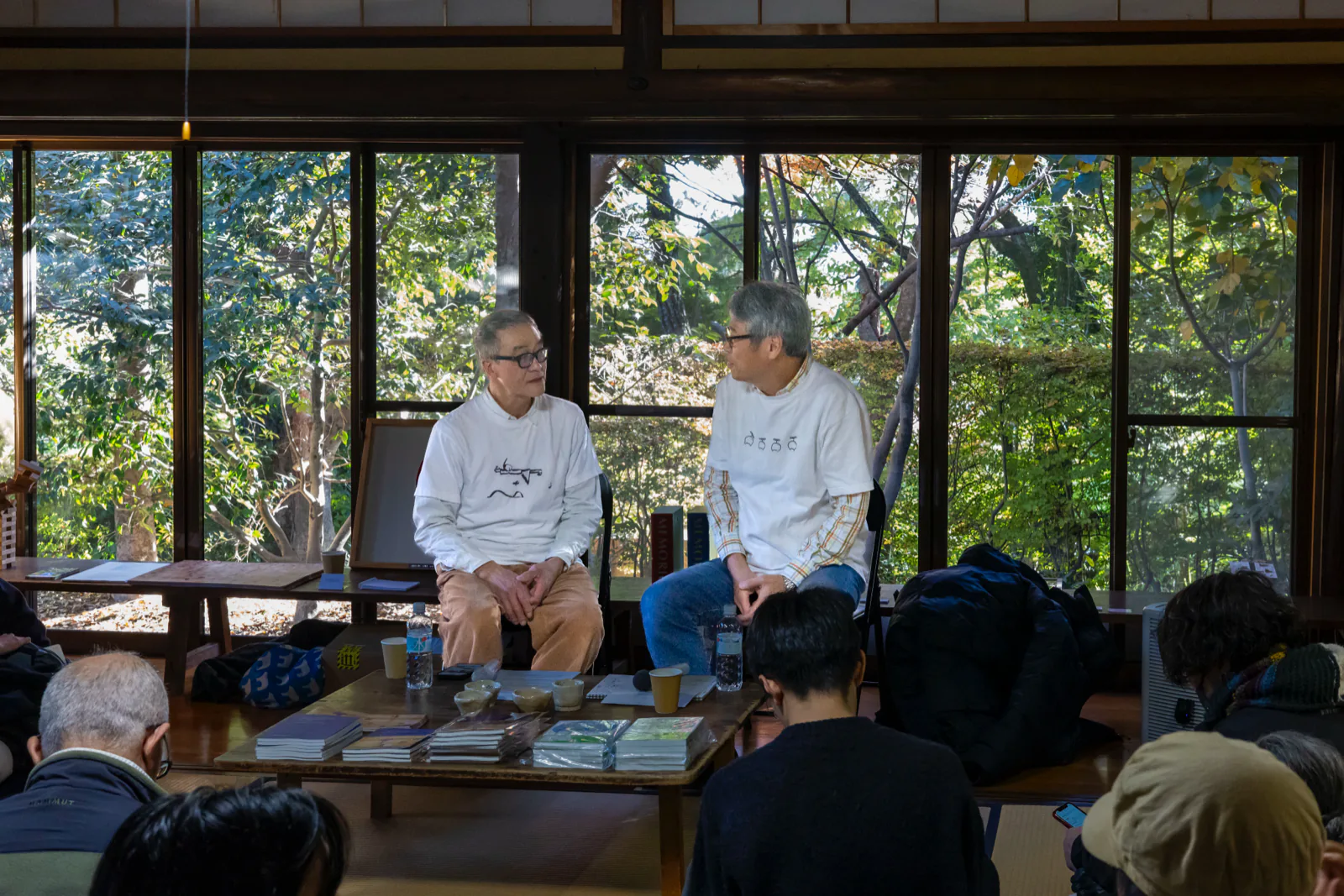 Eiji Watanabe (artist, left) and Eiji Watanabe (neuroscientist, right) talking side by side in the Rest Building